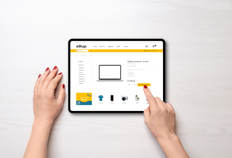 Frau klickt auf Tablet in einem e-Shop auf kaufen